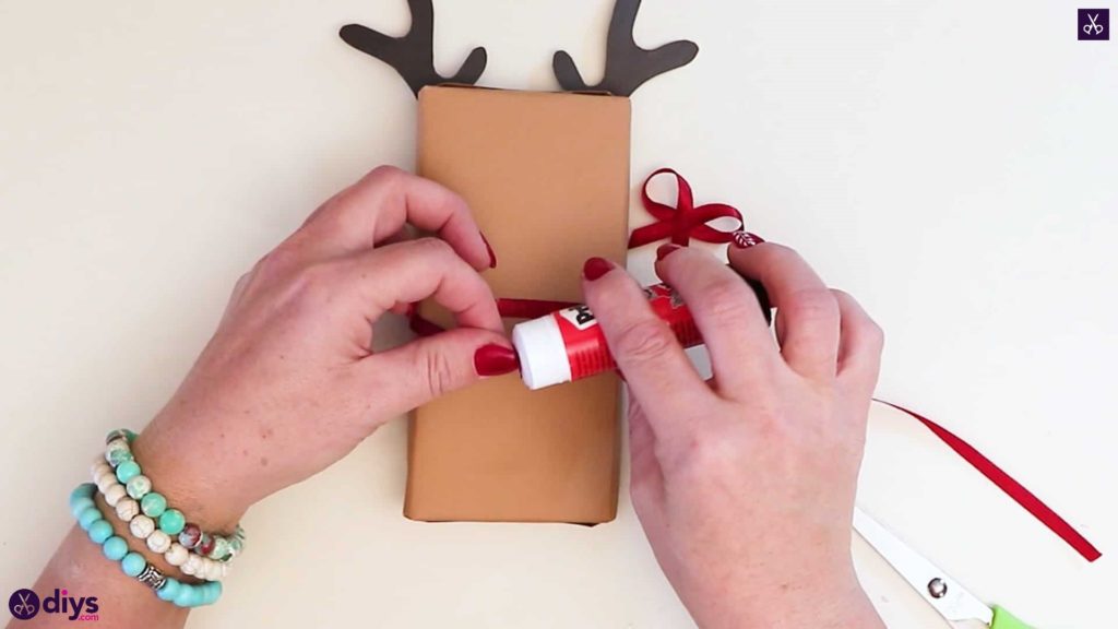 Emballage cadeau de renne de bricolage pour Noël, appliquer un adhésif