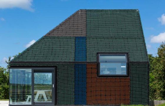 Petite maison en bois recouverte de filets colorés