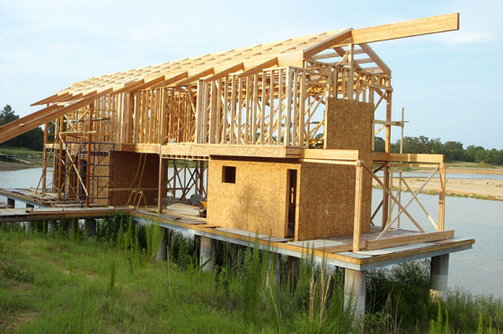 Construction au deuxième étage d'une maison en bois, on peut voir les tiges en bois