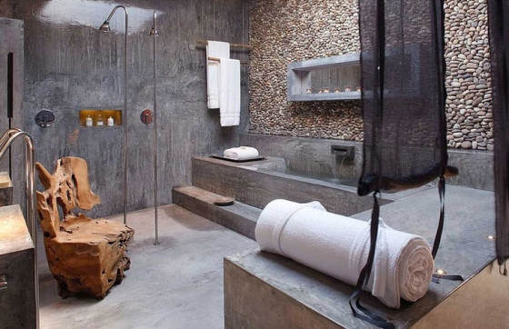 Conception de salle de bain originale avec mur en pierre roulée et mur en béton
