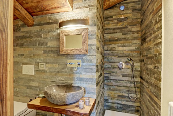 Salle de bain avec carrelage en pierre rectangulaire et lavabo en pierre