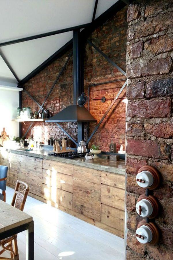 Cuisine industrielle avec meubles en bois et mur de briques avec beaucoup de lumière